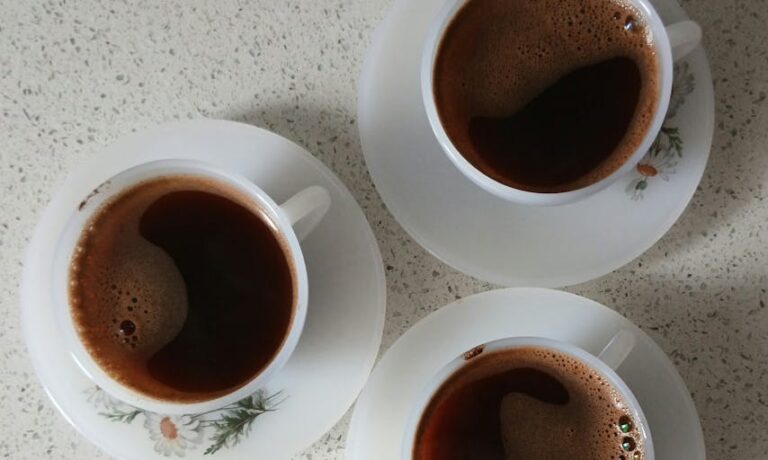 Photo by Melike Baran Three elegant Turkish coffee cups on saucers seen from above, showcasing a warm and inviting setting.