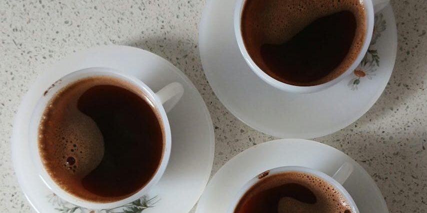 Three elegant Turkish coffee cups on saucers seen from above, showcasing a warm and inviting setting.