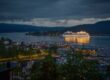 Large cruise ship docked in a harbor at dusk.