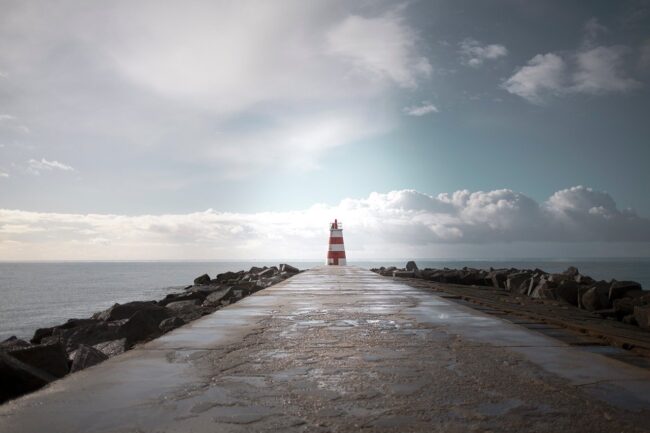lighthouse, pier, atlantic ocean, portugal, coastline, seascape, jetty, walkway, wet pavement, nature, dramatic sky, clouds, horizon, minimalism, leading lines, symmetry, beacon, maritime, seaside, coastal, travel