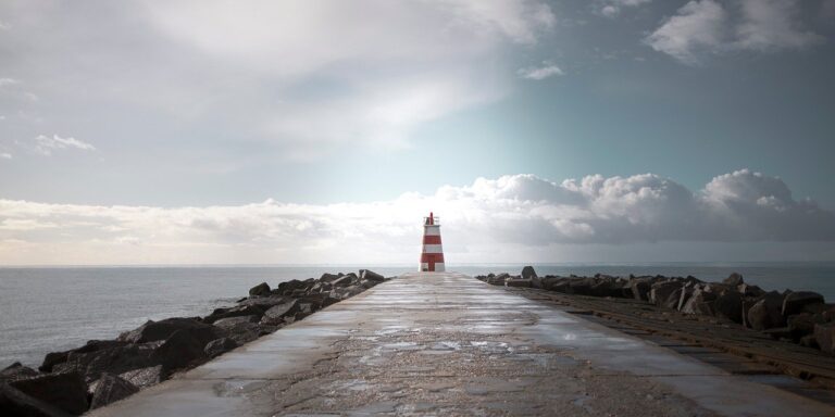 lighthouse, pier, atlantic ocean, portugal, coastline, seascape, jetty, walkway, wet pavement, nature, dramatic sky, clouds, horizon, minimalism, leading lines, symmetry, beacon, maritime, seaside, coastal, travel